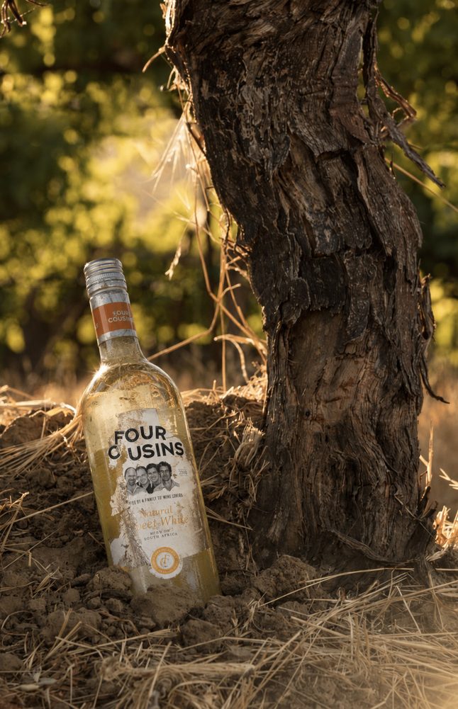 Four Cousins bottle resting against a vine trunk